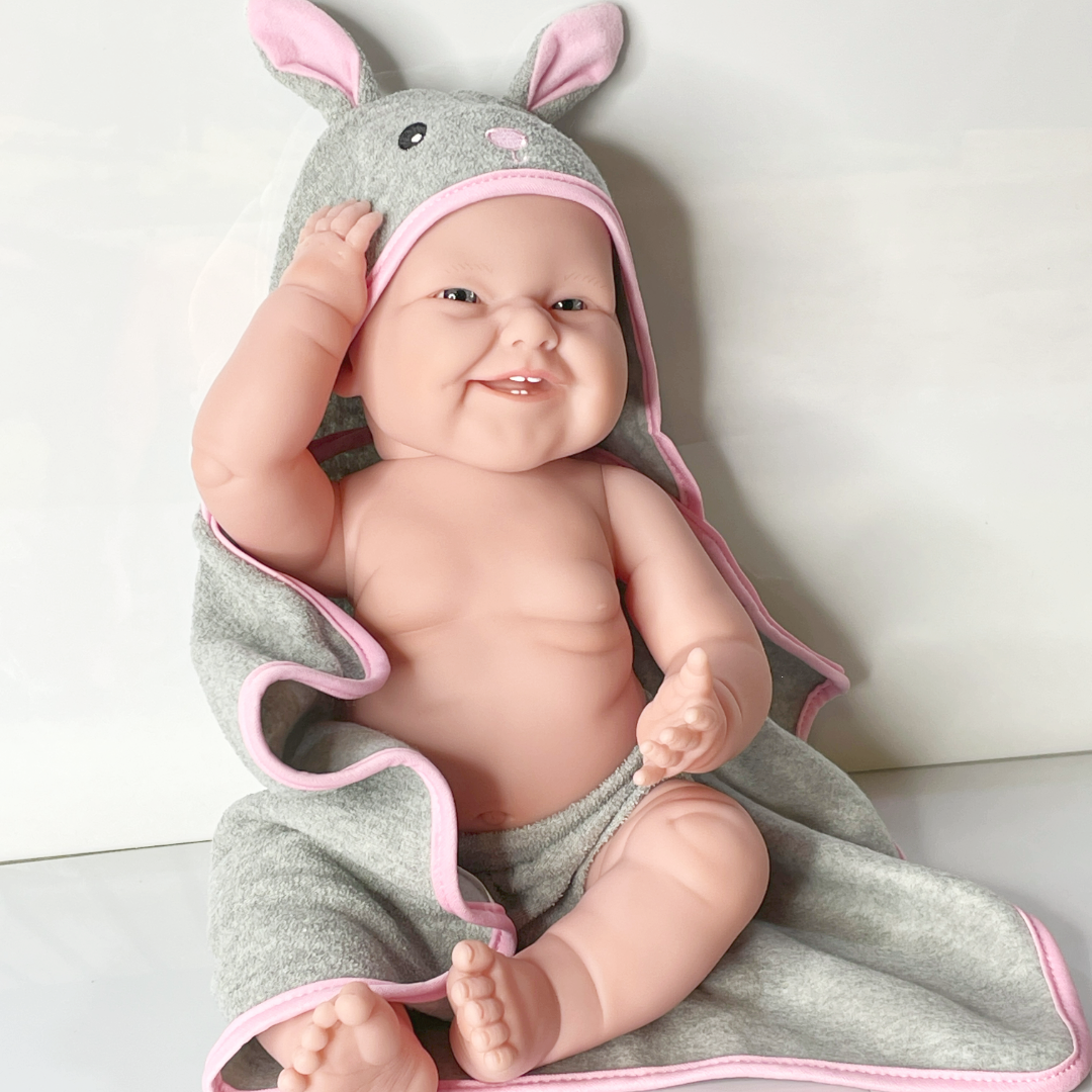 Therapy Doll wearing a gray and pink bunny bath  wrap after a bath.